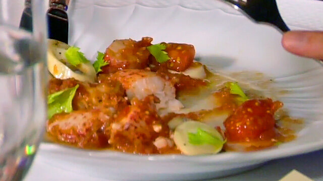 lobster salad with tomatoes on a white plate